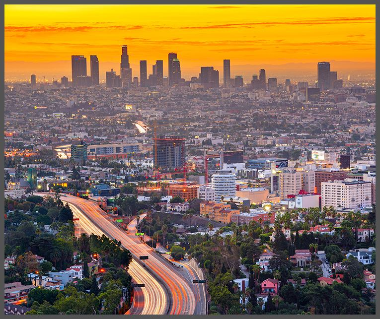 A view of downtown Los Angeles at sunset with skyscrapers in the background