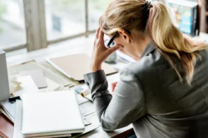 A distressed woman at her work desk.
