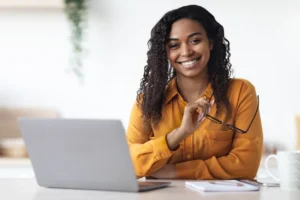 An independent contractor smiling in front of a laptop.