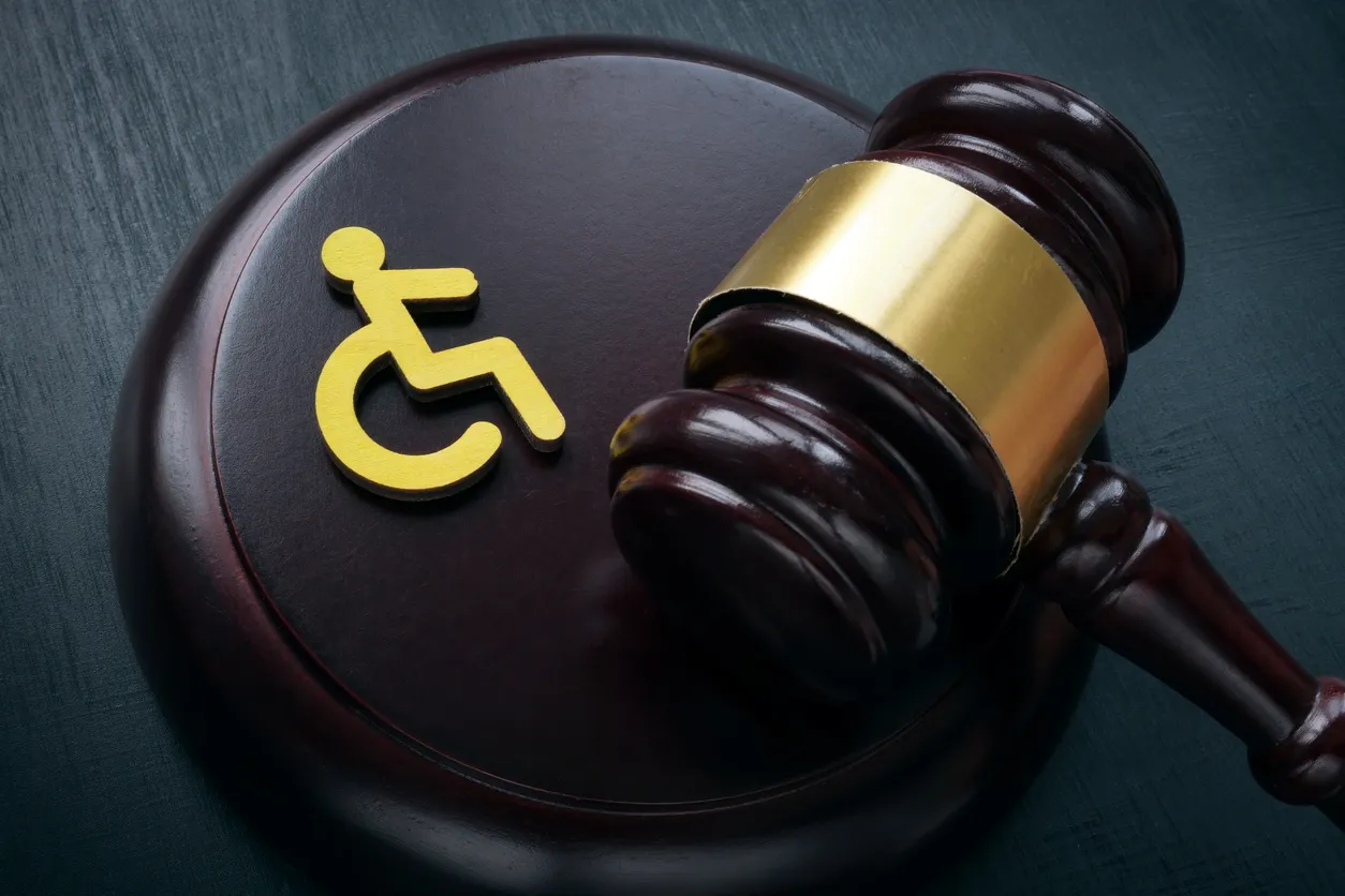 A gavel with a gold wheelchair symbol.