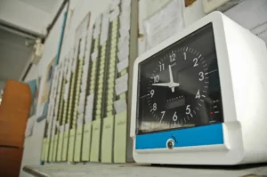 A wall of employee timesheets and a clocking system.
